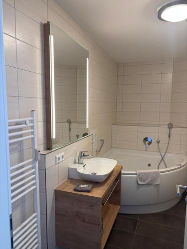 a bathroom with a sink and a tub with a mirror at Apartment 117 in Feldberg