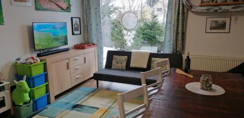 a living room with a dining room table and a television at Qvintesencia Terchová in Terchová