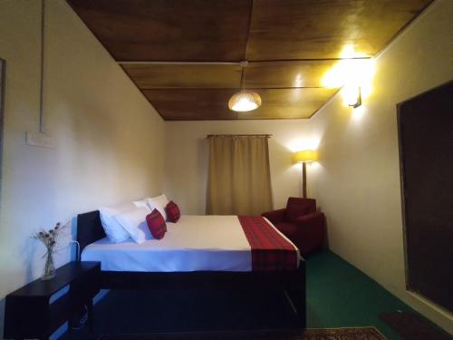 a hotel room with a bed and a chair at Meis cottage Umpling in Shillong