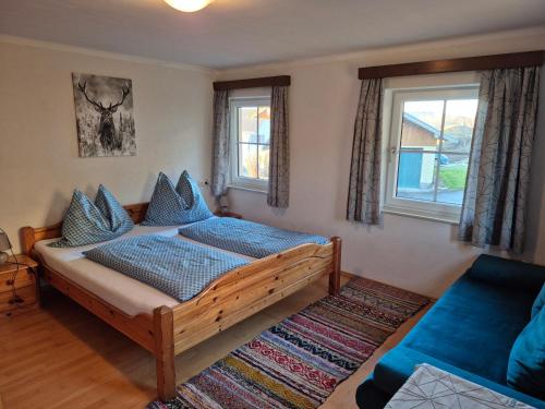a bedroom with a bed and a couch and windows at Ferienhof Edtmeier in Zell am Moos