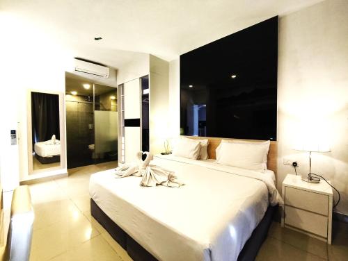 a bedroom with a large white bed with a towel on it at Genting MujiColdInn2R2B AT Ion Delemen in Genting Highlands