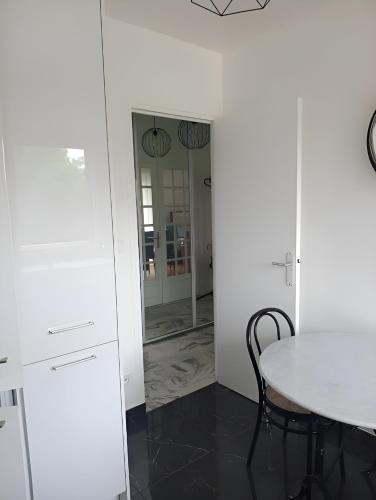 a dining room with a table and a mirror at La Précieuse, RER A Proche Paris in Saint-Maur-des-Fossés