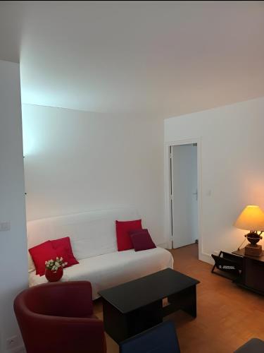a white couch with red pillows in a living room at La Précieuse, RER A Proche Paris in Saint-Maur-des-Fossés