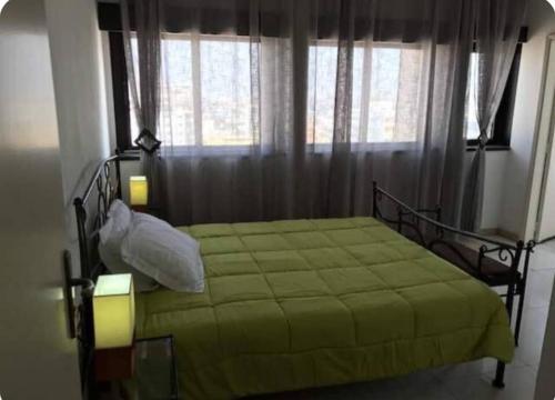 a bedroom with a green bed in front of a window at Grand et chic appartement in Dakar