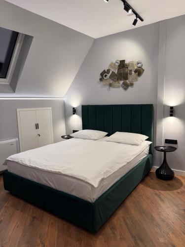a bedroom with a large bed with a green headboard at RotHaus Old Town Sibiu in Sibiu