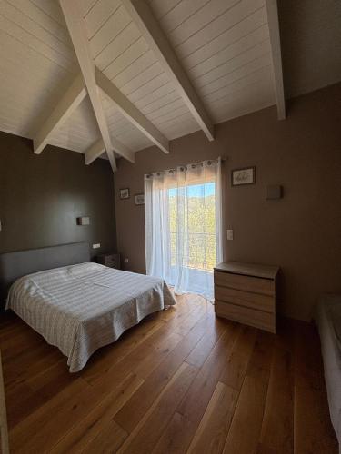 a bedroom with a bed and a large window at VILLA Cala D'orzu in Coti-Chiavari