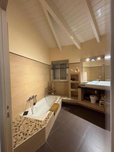 a large bathroom with a tub and a sink at VILLA Cala D'orzu in Coti-Chiavari