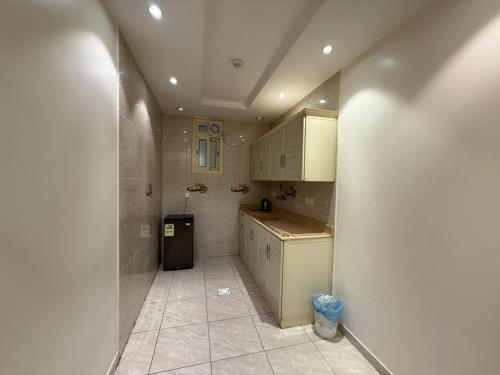 a kitchen with white cabinets and a trash can at فيو المنسك in Abha