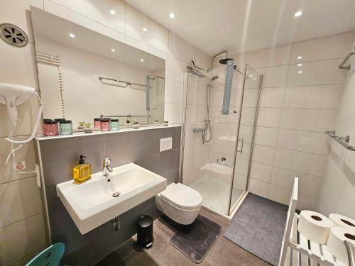 a bathroom with a sink and a toilet and a shower at Ferienwohnung Sunset - Traumhafter Seeblick & Sauna in Steinhude in Wunstorf