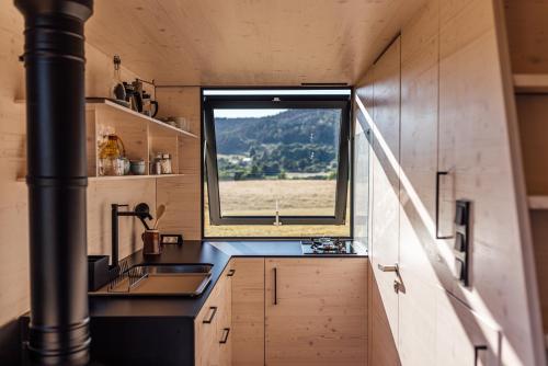 a small kitchen with a sink and a window at Glamping Silverboy in Toužim