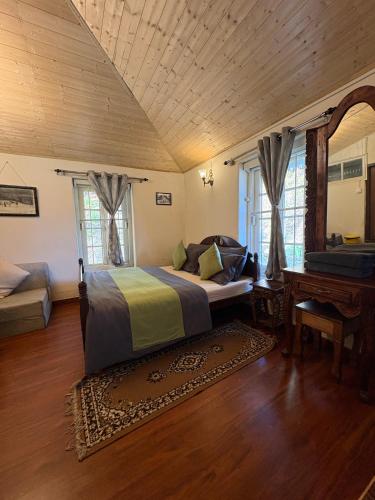 a bedroom with a bed and a piano in a room at Rose Villa Colonial Heritage Bungalow, Takdah in Takdāh