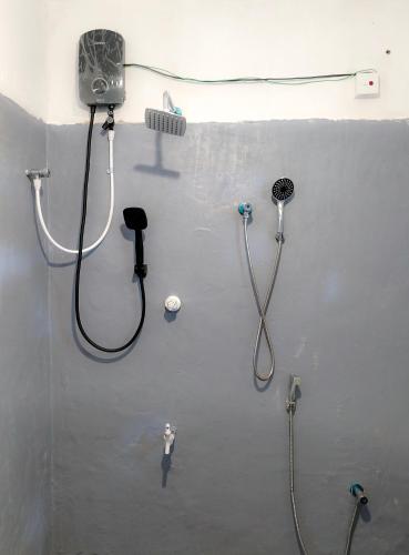 a bathroom with a shower and a shower head at Indrasiri Villa Midigama in Kumbalgama