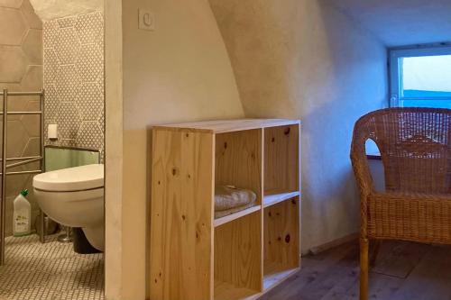 a bathroom with a toilet and a sink and a chair at Cévennes et Causse Mejean in Dargilan
