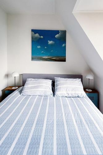 a bedroom with a large bed with two pillows at Appartement met uitzicht over de Wadden Zee in Oost-Vlieland