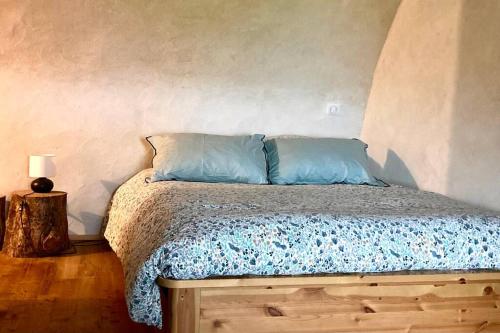 a bed with two pillows on it in a room at Cévennes et Causse Mejean in Dargilan