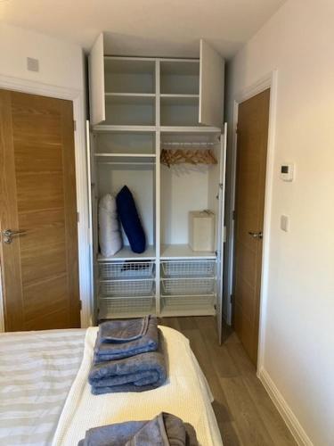 a bedroom with a bed and a closet with shelves at Eco House by Science Park, Airport and City Centre in Exeter