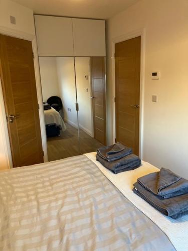 a bedroom with a bed with two towels on it at Eco House by Science Park, Airport and City Centre in Exeter