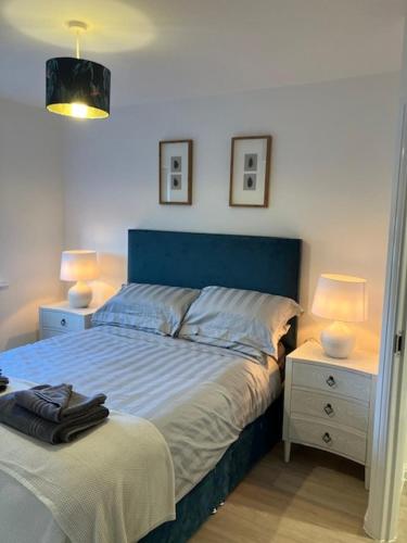 a bedroom with a blue bed and two night stands at Eco House by Science Park, Airport and City Centre in Exeter