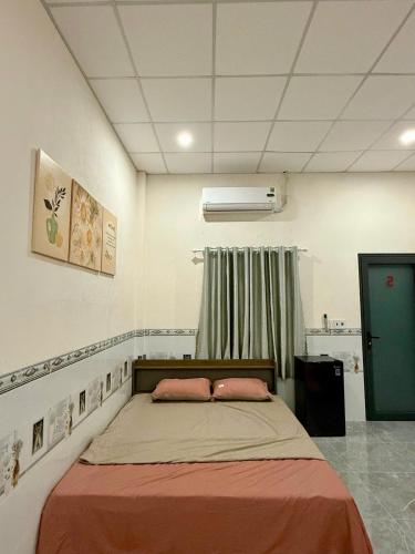 a bedroom with a bed with two pink pillows at Thùy Vinh Homestay in Phú Quốc