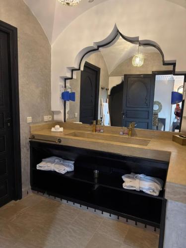 a bathroom with a sink and a large mirror at Royal Moroccan House in Marrakesh