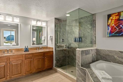 a bathroom with a shower and a tub and a sink at Club Wyndham Grand Desert in Las Vegas