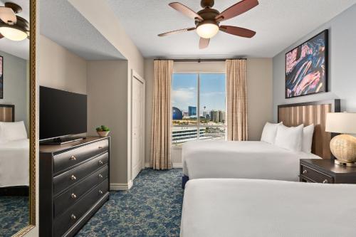 a hotel room with two beds and a mirror at Club Wyndham Grand Desert in Las Vegas