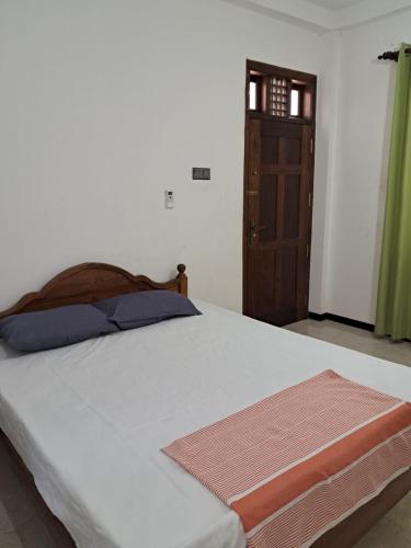 a bedroom with a bed and a wooden door at Home stray 7 in Matara