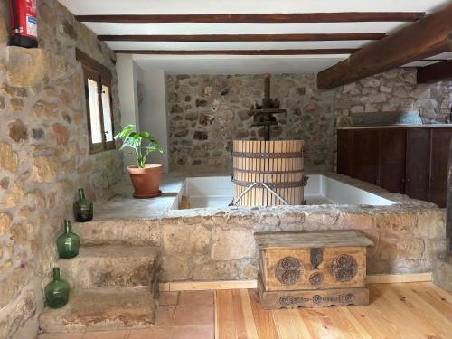 a kitchen with a bath tub in a stone wall at Golindo Goikoa in Getaria