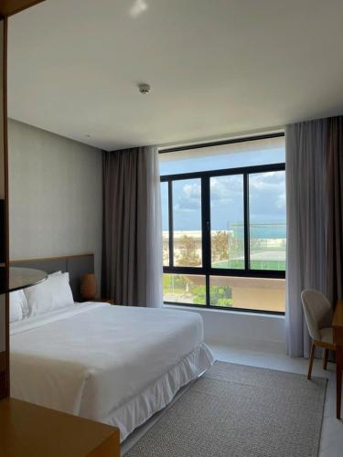 a hotel room with a bed and a large window at Wyndham garden villa 304 in Cam Lâm