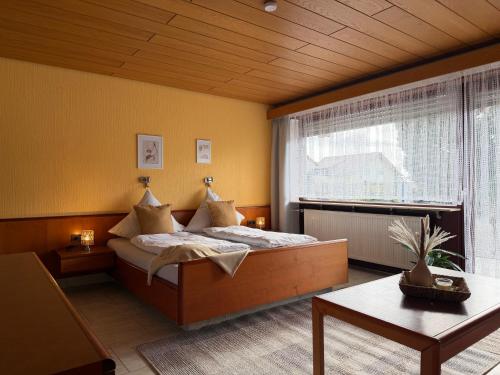 a bedroom with a bed and a large window at Hotel Garni Sebastian in Kirrweiler