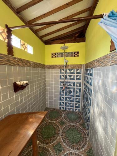 a bathroom with a shower and a wooden table at Amelia Villa in Montongbuwoh