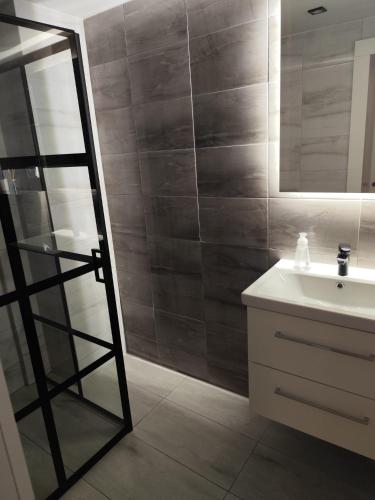 a bathroom with a sink and a mirror at Pokoje Koral in Mikołajki