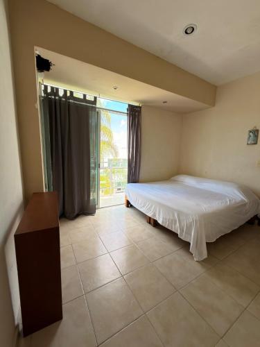 a bedroom with a bed and a large window at 20 minutes from Chapala, Pool &Grill in Buenavista