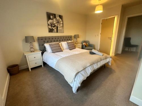 a bedroom with a large bed and a night stand at 4BR Cheshire East/Townhouse/Central - Close to Bentley in Crewe