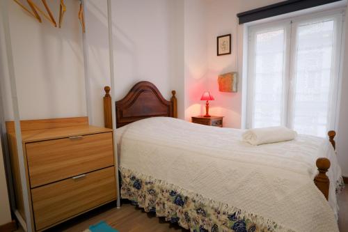 a bedroom with a bed and a dresser and a window at Alojamento da Zá in Vila Pouca de Aguiar