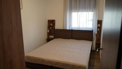 a bedroom with a bed in a room with a window at Lomb Lak Vendégház in Kozármisleny