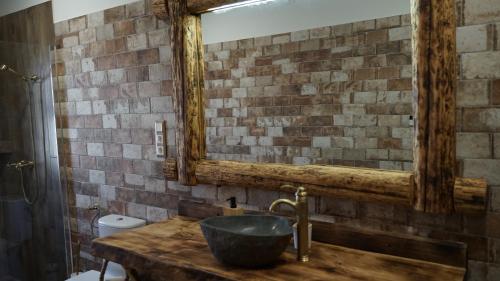 a bathroom with a wooden sink and a mirror at Lomb Lak Vendégház in Kozármisleny