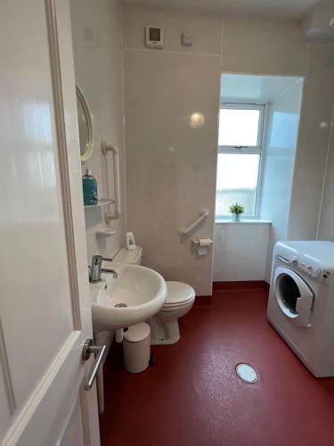a bathroom with a white toilet and a sink at Ashley House Contemporary 4 Bedroom Stay for 13 in Inverness