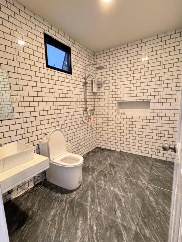 a bathroom with a toilet and a sink and a window at Naruemon in Ban Madua Wan