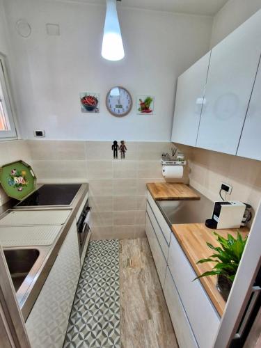 a small kitchen with white cabinets and a sink at Faggi & Quiet in Mandello del Lario