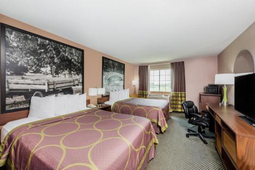 a hotel room with two beds and a flat screen tv at Super 8 by Wyndham Winfield-Quail Ridge Area in Winfield