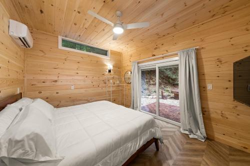 a bedroom with a white bed and a window at Hickory Hideaway Dollywood, Island, LeConte in Pigeon Forge