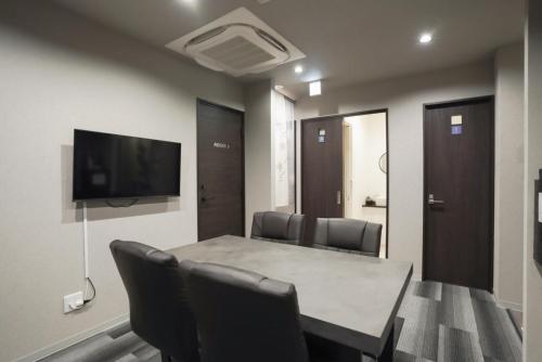 a conference room with a table and chairs and a flat screen tv at Laon Inn Miyakojima in Miyako-jima