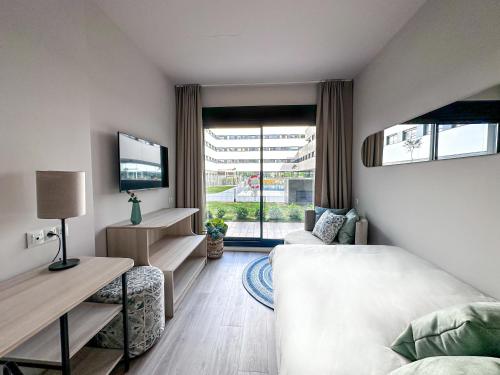 a bedroom with a bed and a tv and a window at Living Experience Granada in Granada