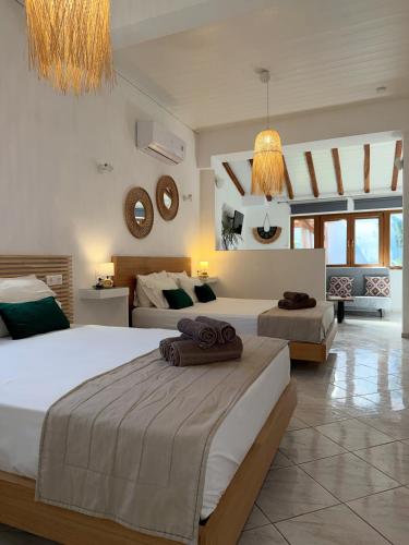 a large bedroom with two beds and mirrors on the wall at Del Sol Suites in Skiathos
