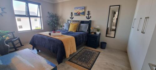 a bedroom with a bed with a blue comforter at MaKarLi Blu in St. Helena Bay