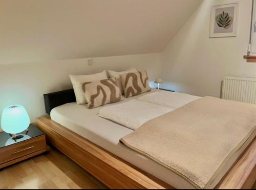 a bedroom with a bed with white sheets and a lamp at Molers in Stühlingen