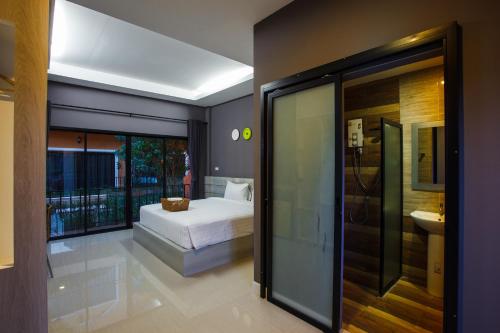a bedroom with a bed and a bathroom at Sata House Boutique Resort in Nakhon Ratchasima