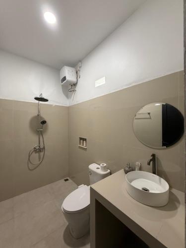 a bathroom with a white toilet and a sink at Uma Danu Villas Kintamani in Kubupenlokan