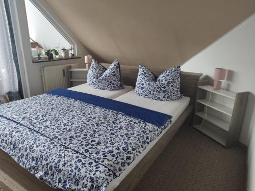 a bedroom with a bed with blue and white sheets and pillows at Hoernchens-Ferienwohnung in Neuenkirchen
